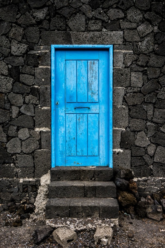 Puerta azul en un muro de piedra